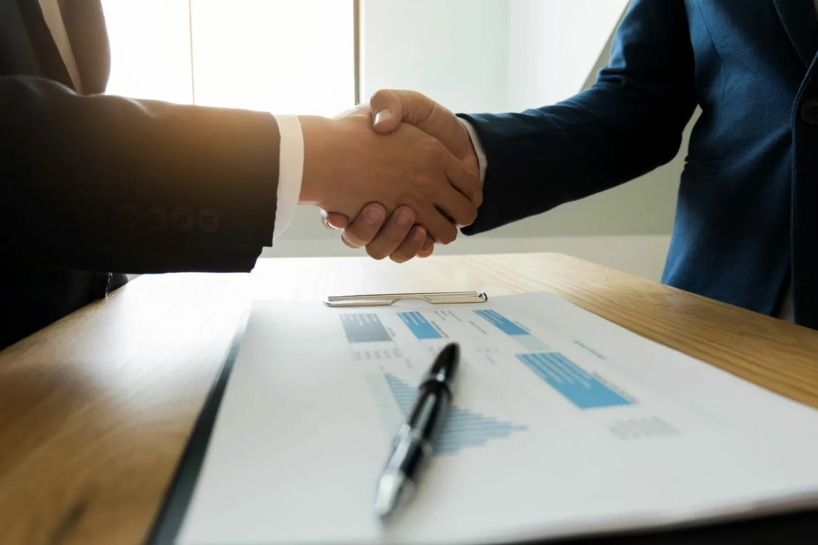 Business partners closing a creator collaboration deal with contract and documents